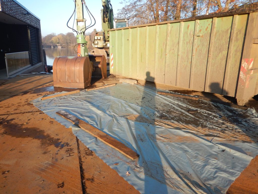 Folie vor Baucontainer mit Bagger im Hintergrund